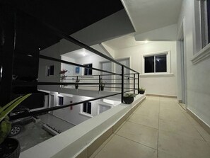 Un edifici residencial amb diversos pisos, un balcó i una escala.