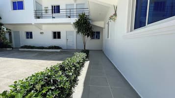 Un bâtiment moderne doté d’un toit plat, de nombreuses fenêtres et d’un sol carrelé aux lignes épurées.