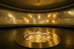 A circular room with a reflective floor and a wall adorned with spherical decorations. - Ayenda CGH Bogota Airport (Bogotá)