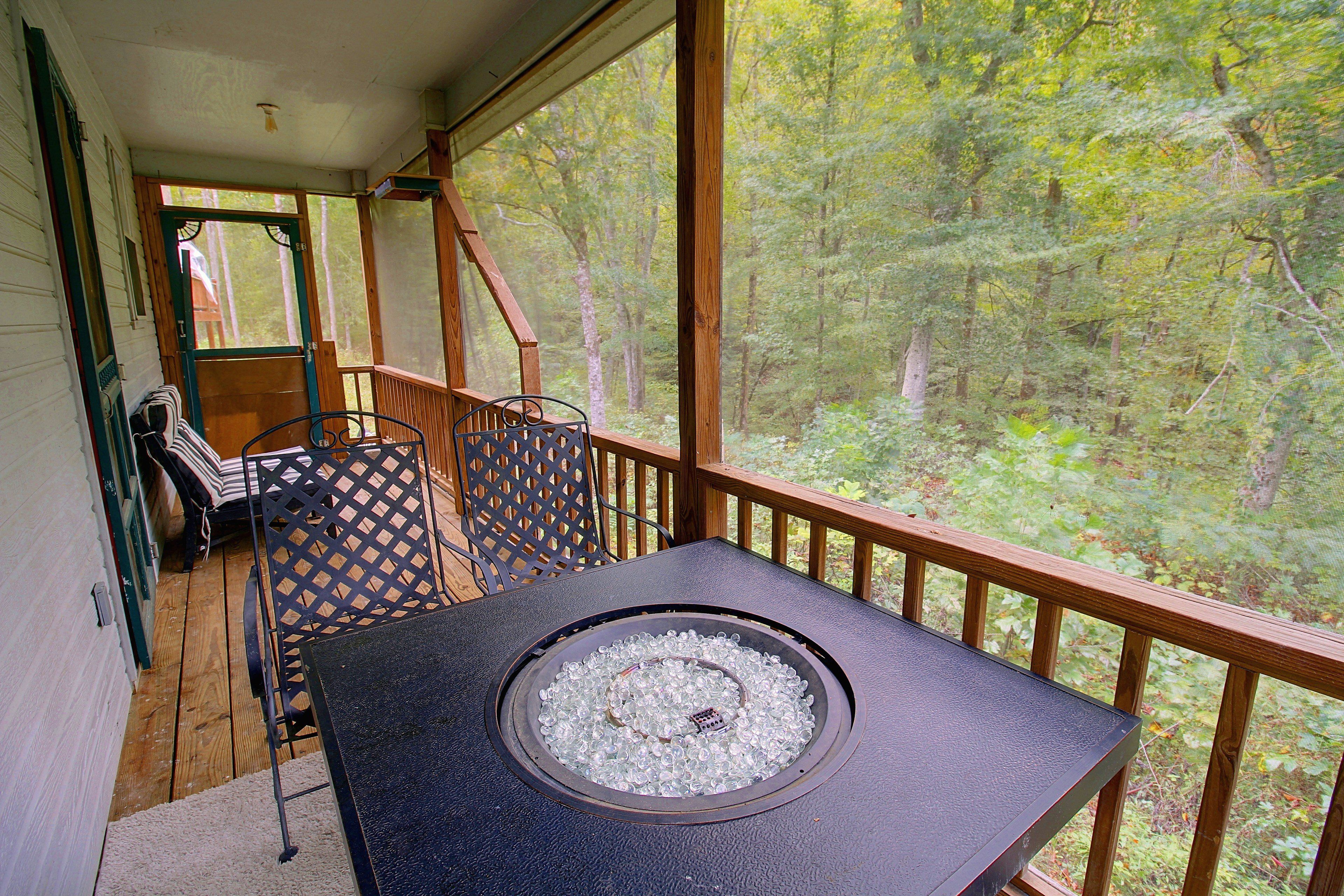 Una terraza con mesa y sillas, con vistas a un bosque.