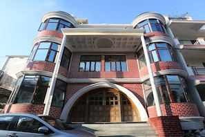 A multi-story building with a prominent arched entrance, large windows, and a symmetrical facade. - Hotel O Tulip Inn (Gorakhpur)