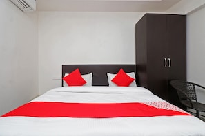Una habitación de hotel con una cama, un armario y una silla.