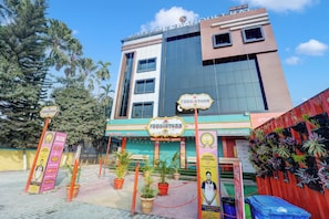 A building with multiple signs for restaurants and a Coca-Cola advertisement. - HOTEL O RL & BANQUET HALL (Guwahati)