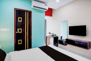 Une chambre d’hôtel équipée d’un lit, d’une télévision, d’un bureau et d’un appareil de climatisation.
