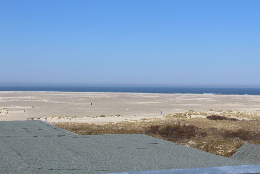 Une vaste étendue de sable plat, sous un ciel dégagé.