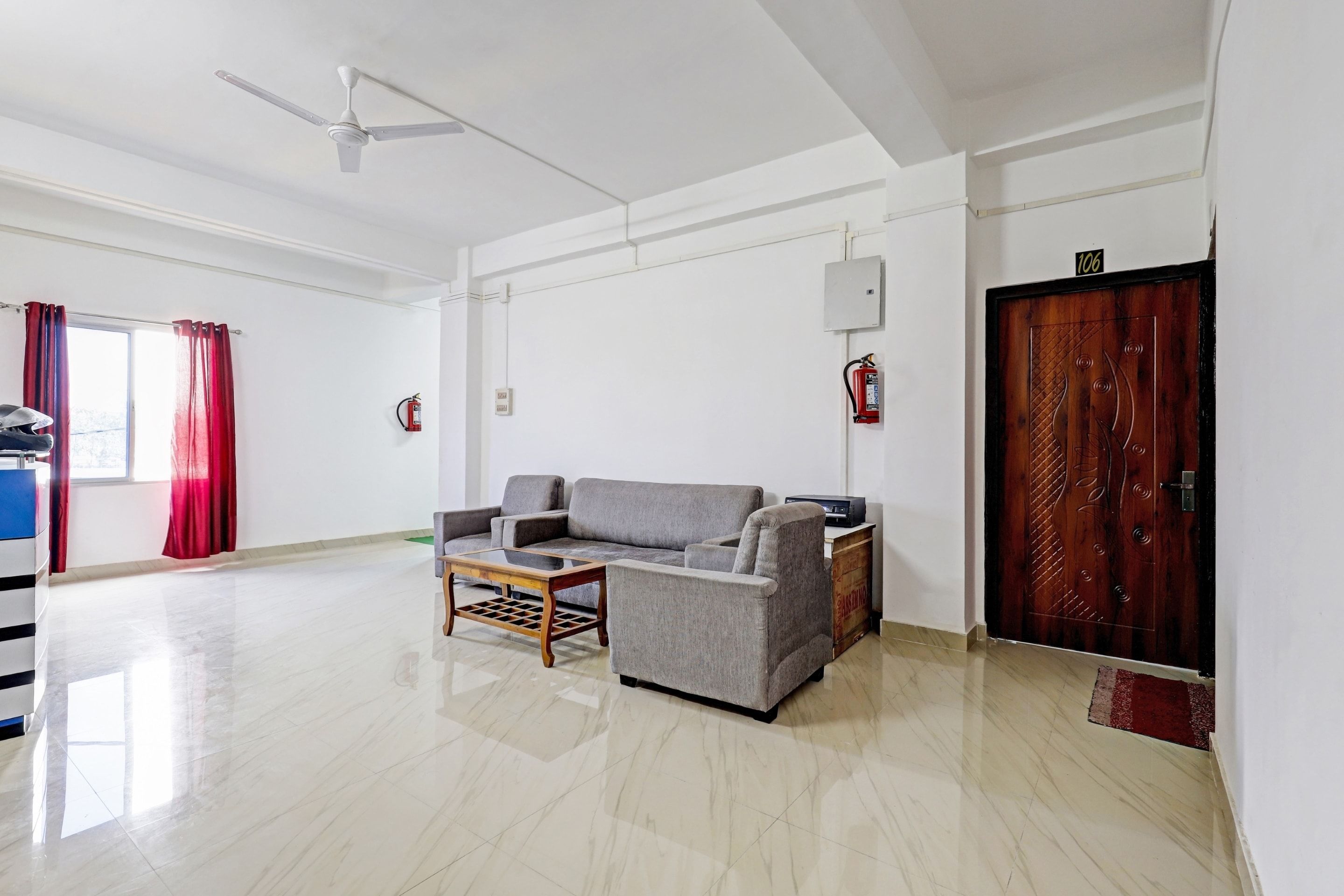 Un salón amplio con un sofá gris, una mesa de centro y un ventilador de techo.