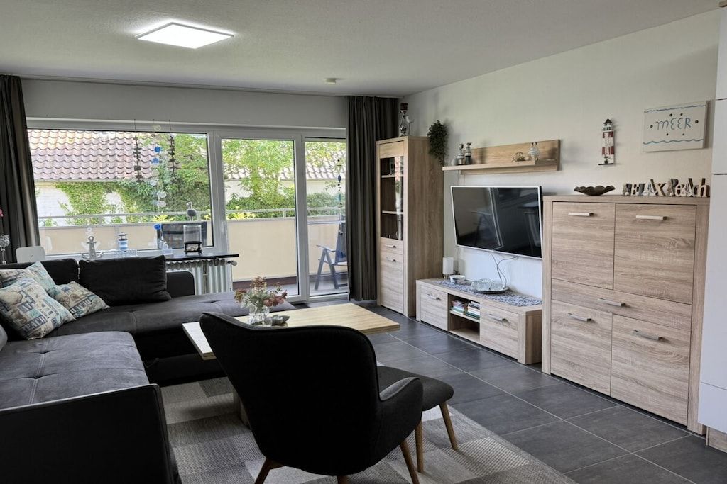 Ein modernes Wohnzimmer mit einer Couch, einem Fernseher und einem Schrank.