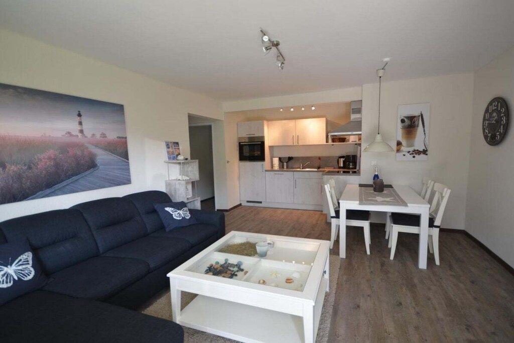 Ein Wohnzimmer mit einer Couch, einem Couchtisch und einem Gemälde eines Leuchtturms.