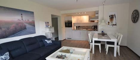Ein Wohnzimmer mit einer Couch, einem Couchtisch und einem Gemälde eines Leuchtturms.