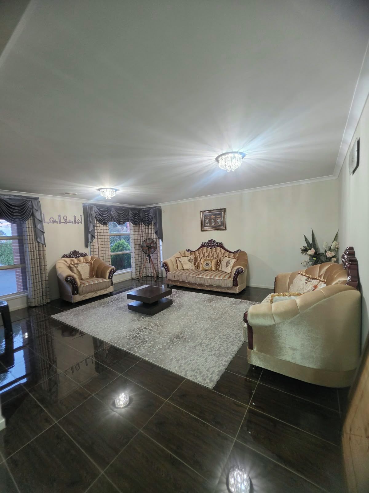 A spacious living room with two sofas, a coffee table, and a chandelier.