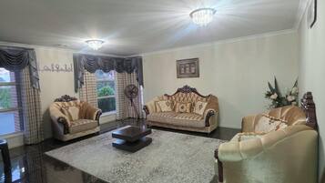 A spacious living room with two sofas, a coffee table, and a chandelier.