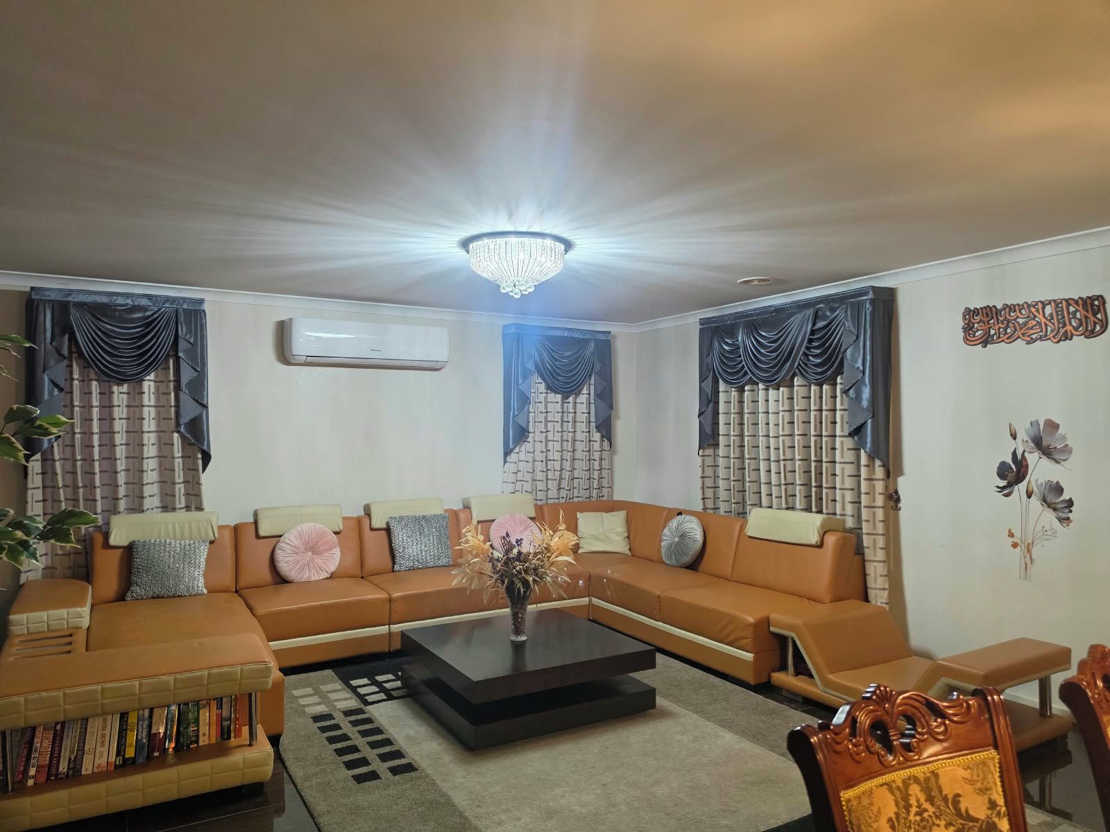 A living room with a sectional sofa, a coffee table, and a bookshelf.