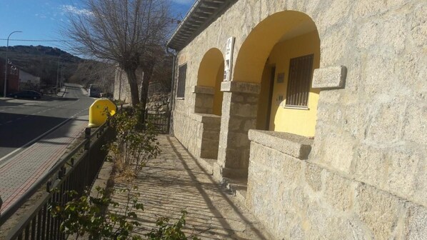 Um edifício de pedra com portais em arco e um caminho pavimentado que o leva.