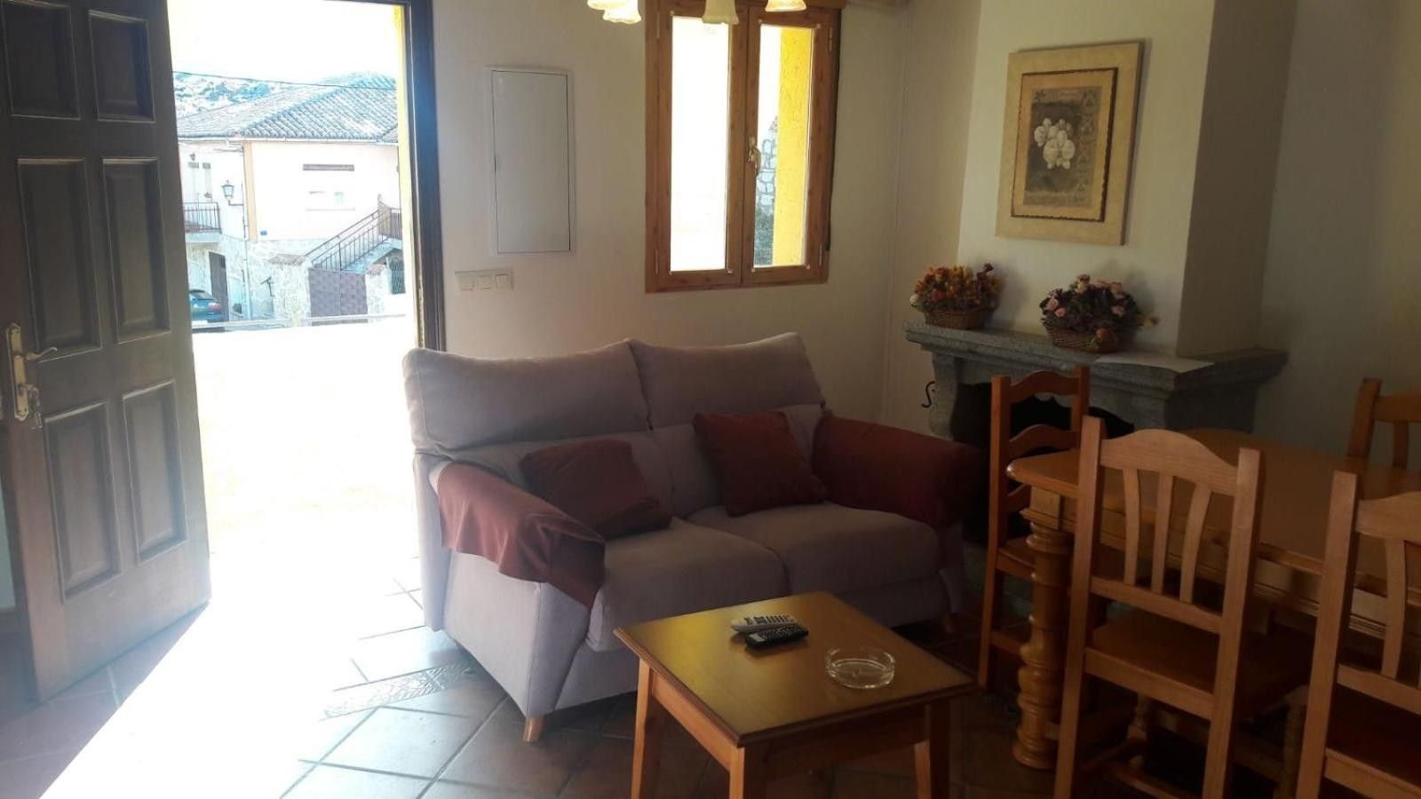 Una sala de estar con un sofá, una mesita y una chimenea.