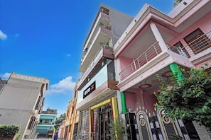 A multi-story building with a prominent hotel sign, balconies, and a gated entrance. - Hotel O JS Palace (Gorakhpur)