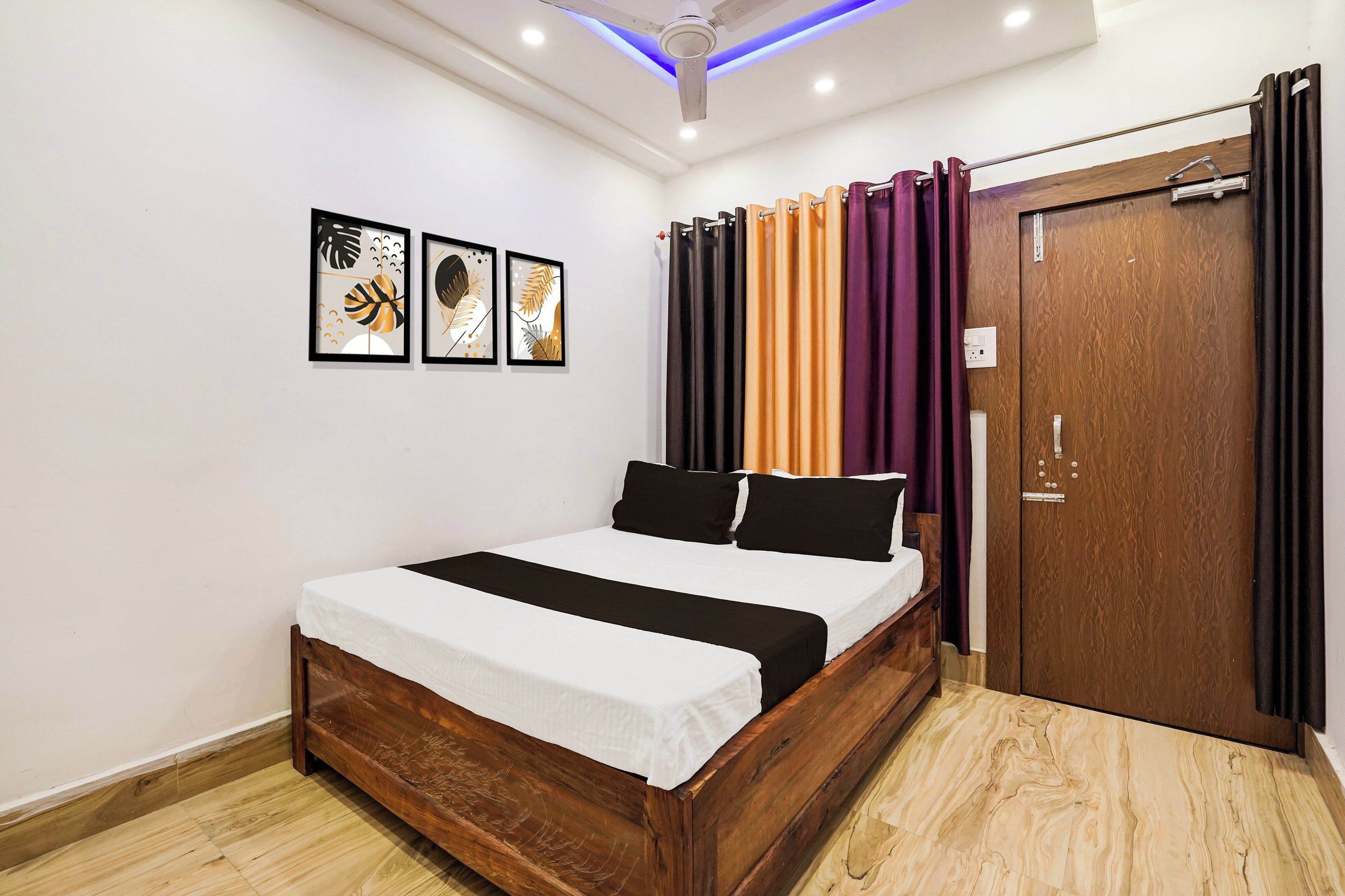 A bedroom with a wooden bed, a ceiling fan, and a door with curtains.