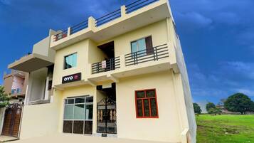 A two-story building with a sign for 'OYO' indicating a hotel or guesthouse.