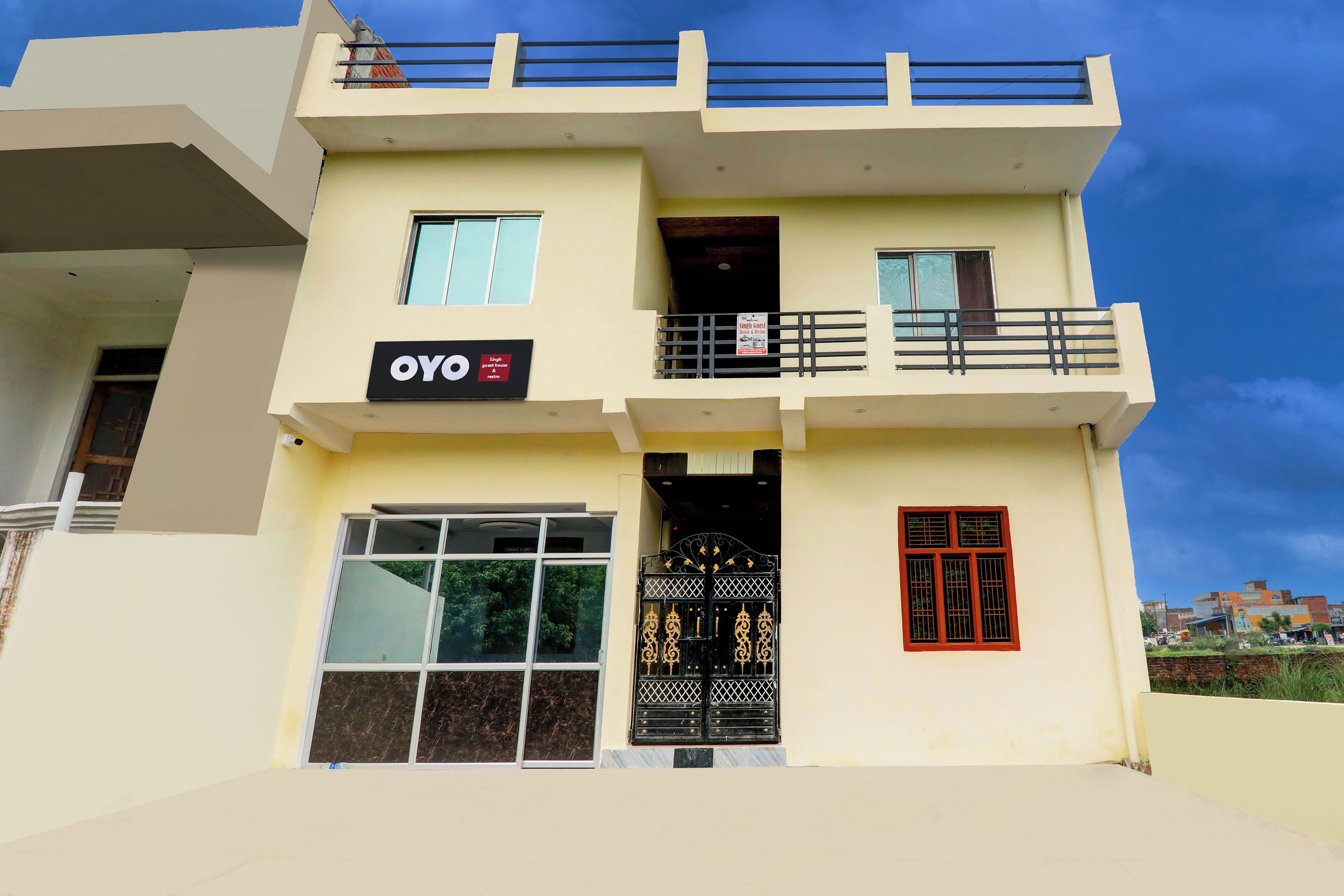 A two-story building with a sign indicating a guest house and a restaurant.