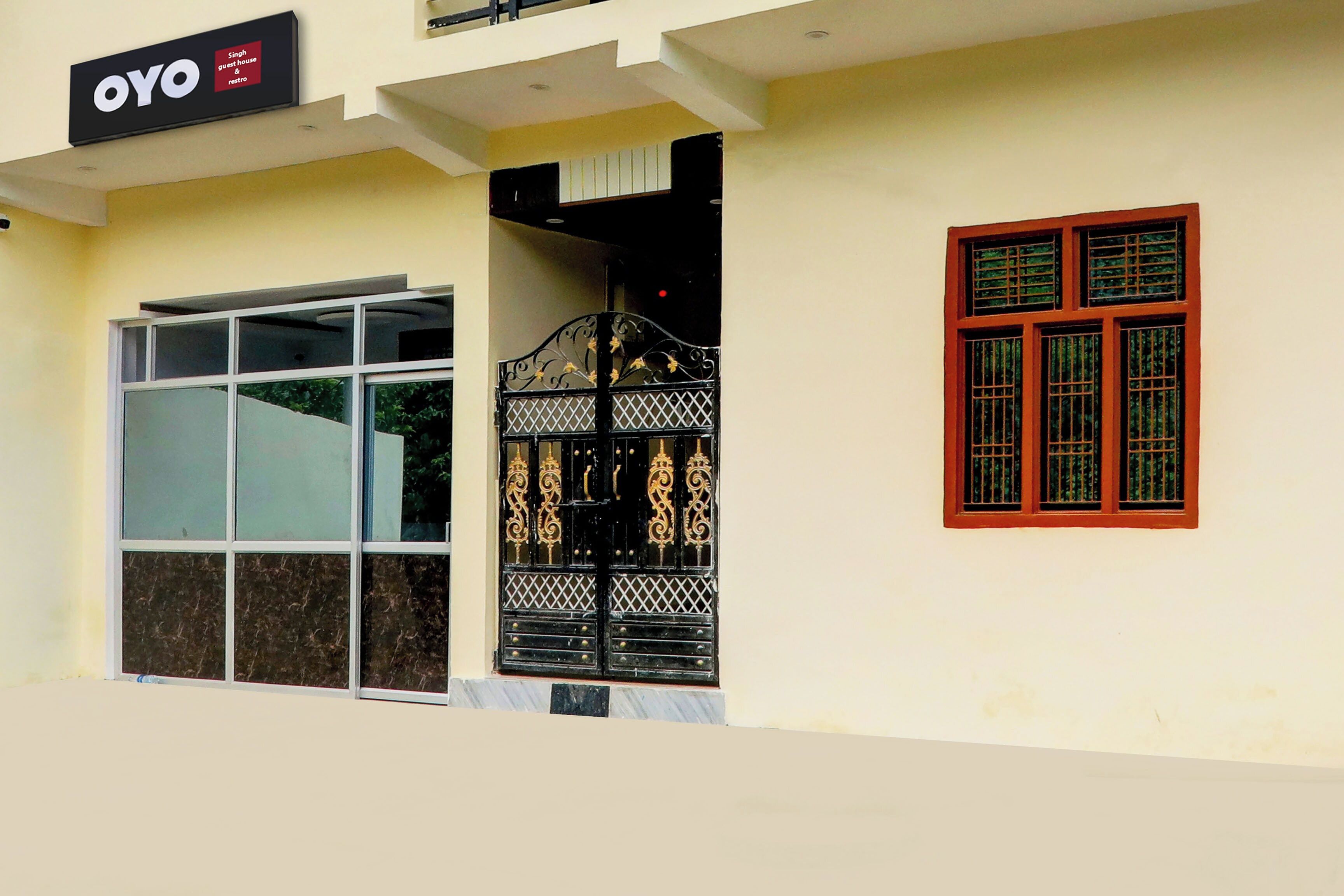 A building with a large glass door and a metal gate with decorative elements.