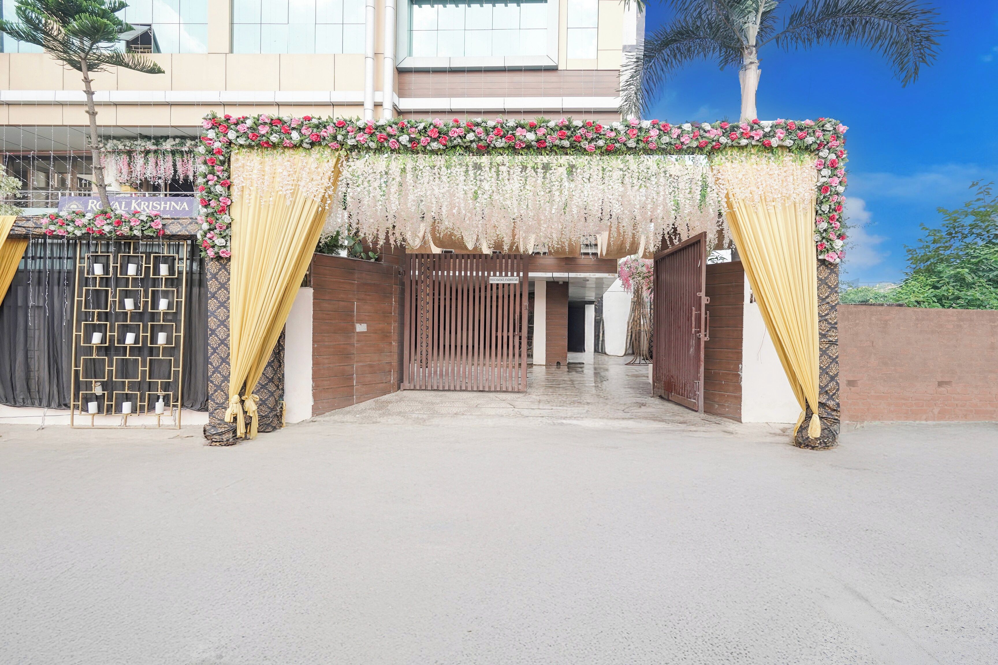 A gated entrance with a floral archway and drapes.