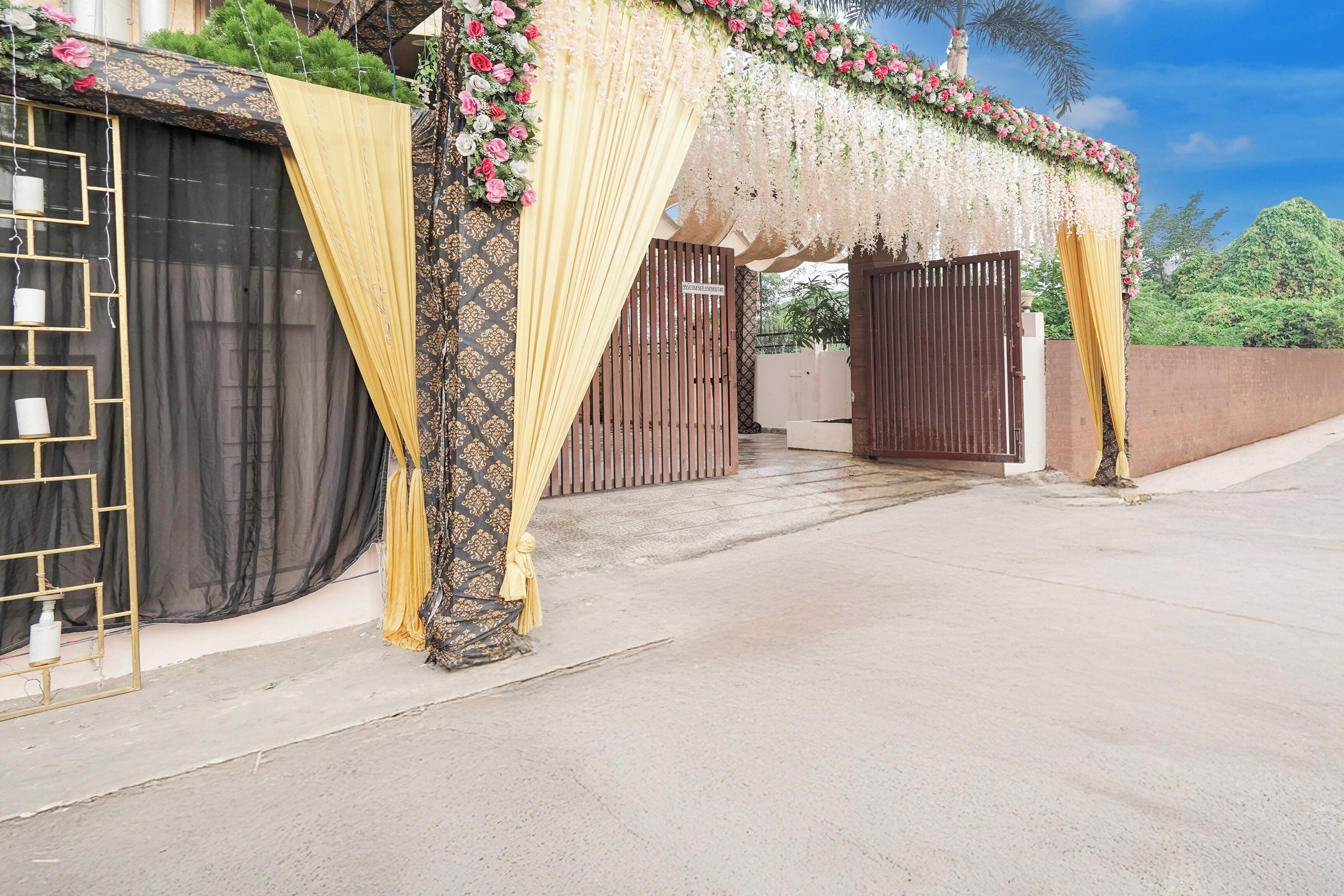 A gated entrance with decorative curtains and floral arrangements.