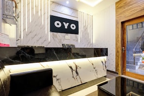 A modern kitchen with a marble countertop, a black and white sign above it, and a wooden door to the right. - Hotel O Skyvilla Home Stay And Guest (Gorakhpur)