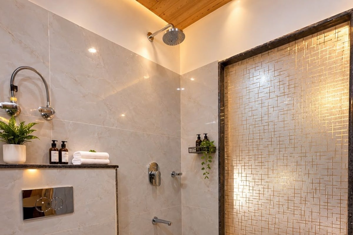 A modern bathroom with a shower, toilet, and a decorative tiled wall.