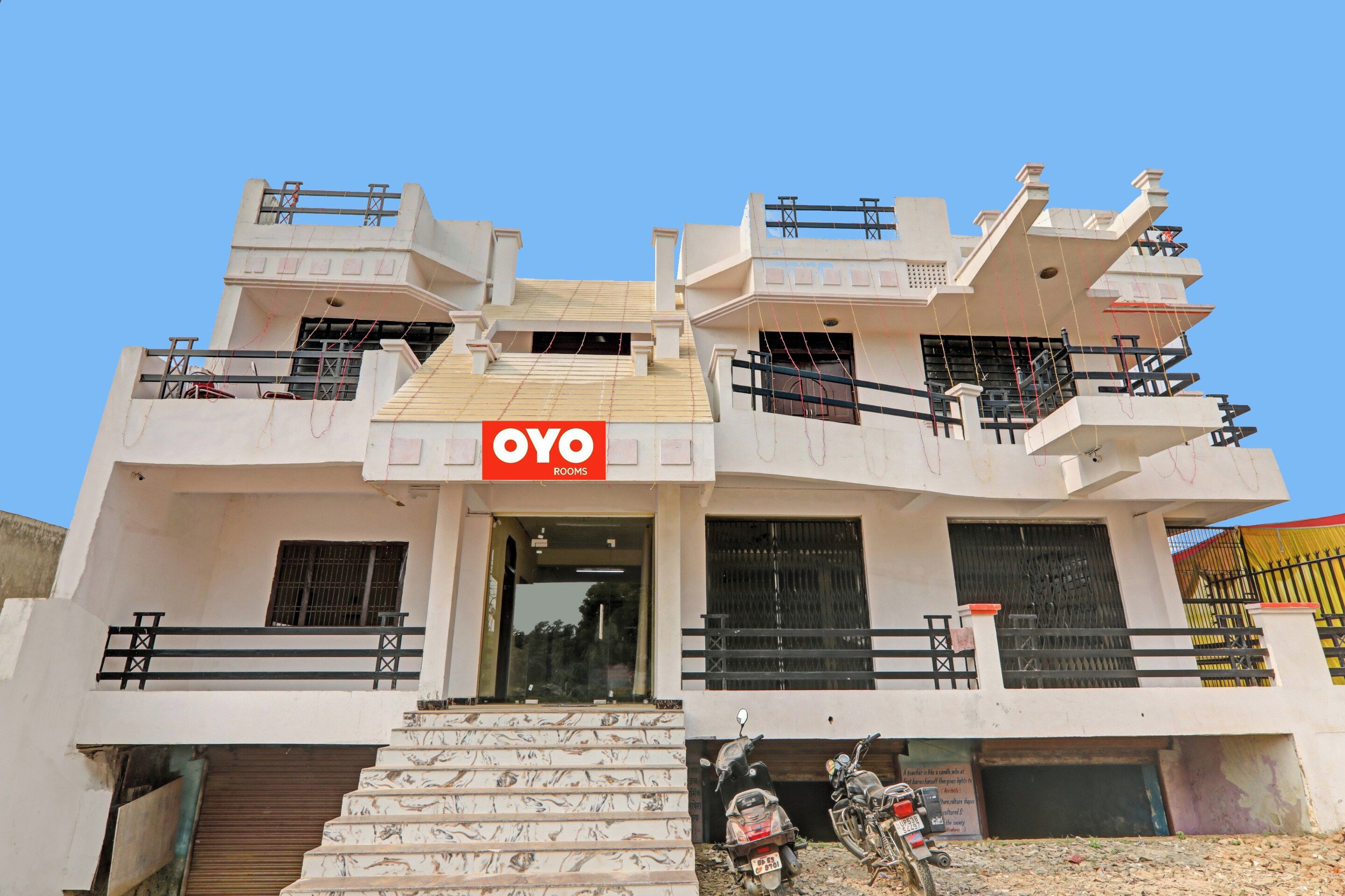 Un edificio de varios pisos con un letrero que dice 'OYO ROOMS'.