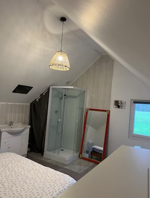 A bedroom with a bed, a bathroom with a shower, a sink, a mirror, and a window. - New Listing (Condé-sur-Sarthe)