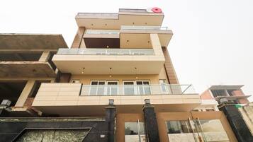 A multi-story building with balconies and a flat roof.