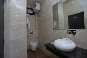 Et moderne badeværelse med en hvid vask, toilet og håndklædetørrestativ.