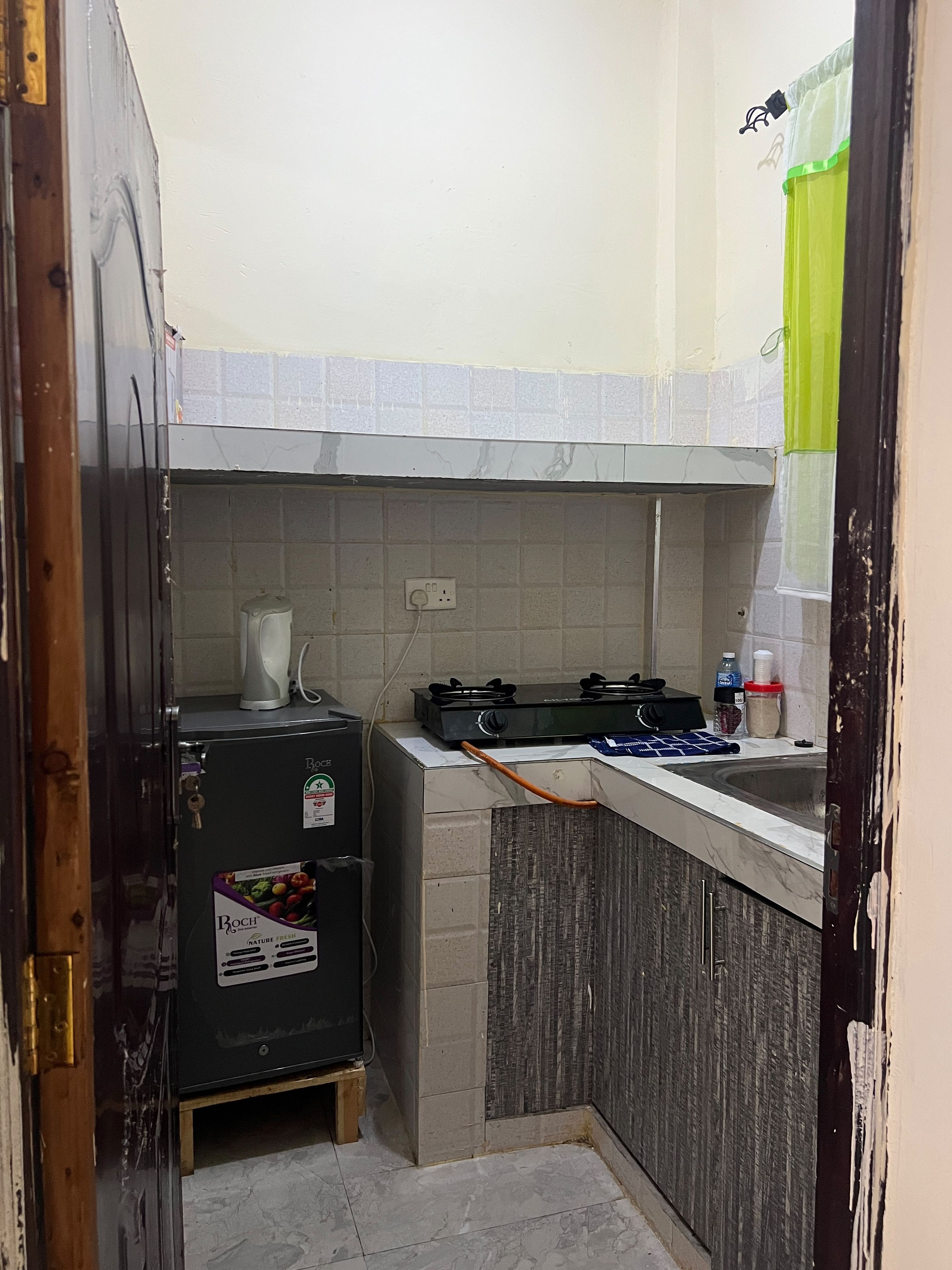 A compact kitchen with a refrigerator, stove, and sink.