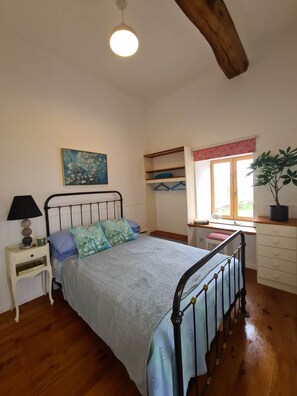 A bedroom with a bed, bedside table, lamp, window, and a painting on the wall. -  Boutique 3-bedroom house in quaint Maupertuis,Swimming Pool, Family Location (Maupertuis)