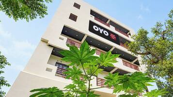 A multi-story hotel building with balconies and a sign that reads 'OYO Hotel Holiday Inn'.