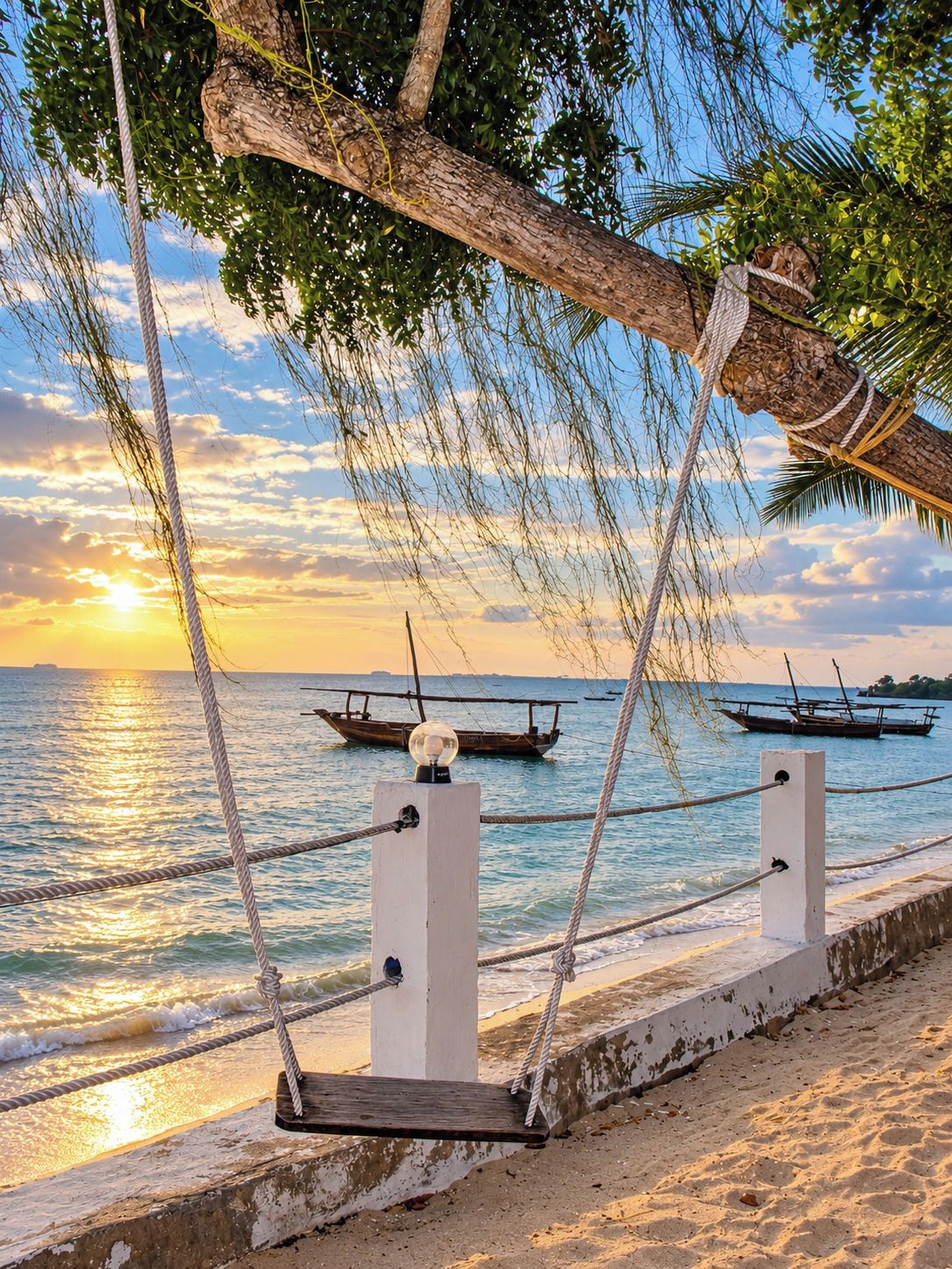 A beach with ropes and a wooden post, a boat in the water, and a sunset.