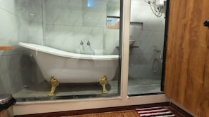 A bathroom with a freestanding bathtub, a shower, and a glass-enclosed shower area. - Hotel Bellora Suites (Rajkot)