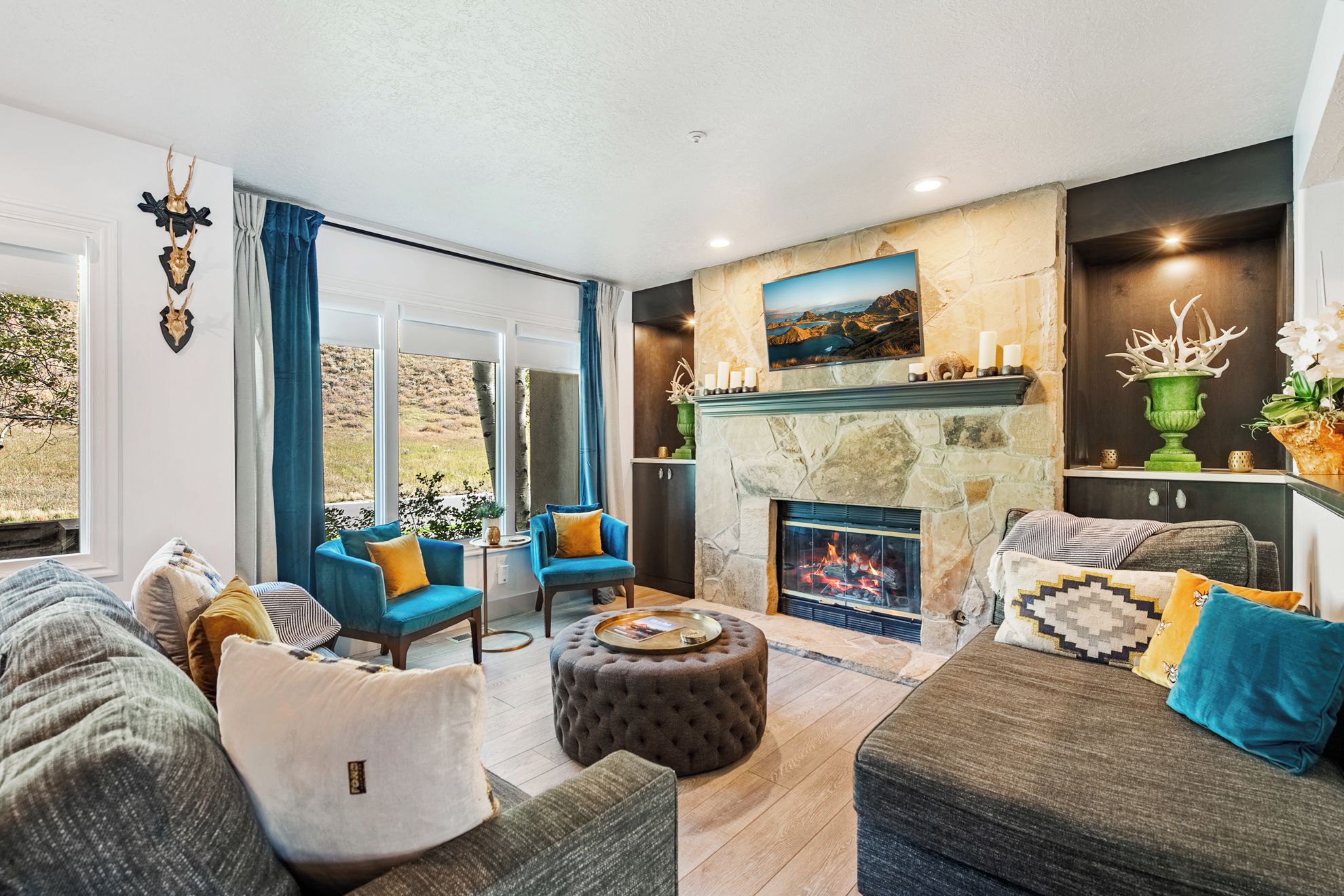 A spacious living room with a fireplace, comfortable seating, and a view of the outdoors.