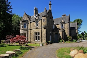 A large stone building with multiple towers and a prominent entrance. - Isla Bank House (Keith)