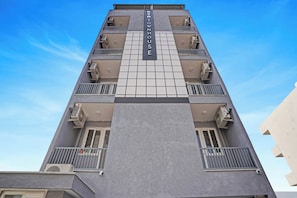 Ein Hochhaus mit mehreren Balkonen und Klimaanlagen.