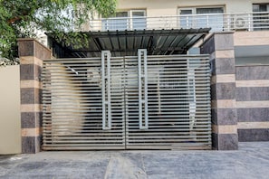 Una entrada protegida con una reja metálica y una estructura de techo encima.