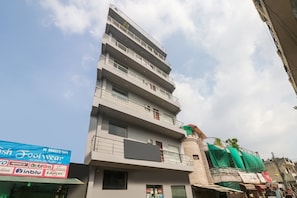 Un edificio de varios pisos con balcones y un cartel anunciando un evento deportivo.