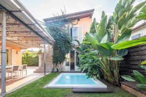 A residential property with a swimming pool, a covered patio, and lush greenery. - New Listing (Forte dei Marmi)