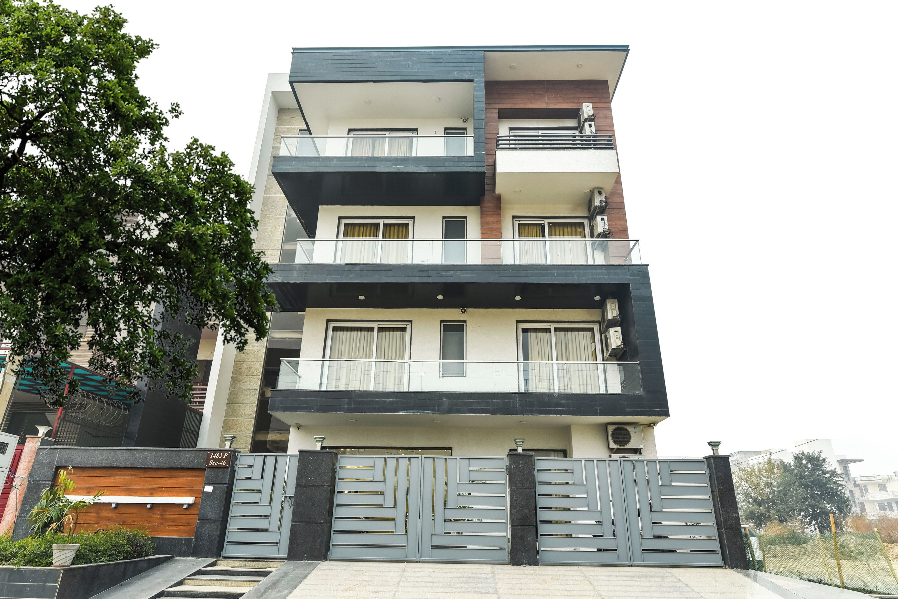 A multi-story residential building with balconies, a gated entrance, and a modern architectural design.