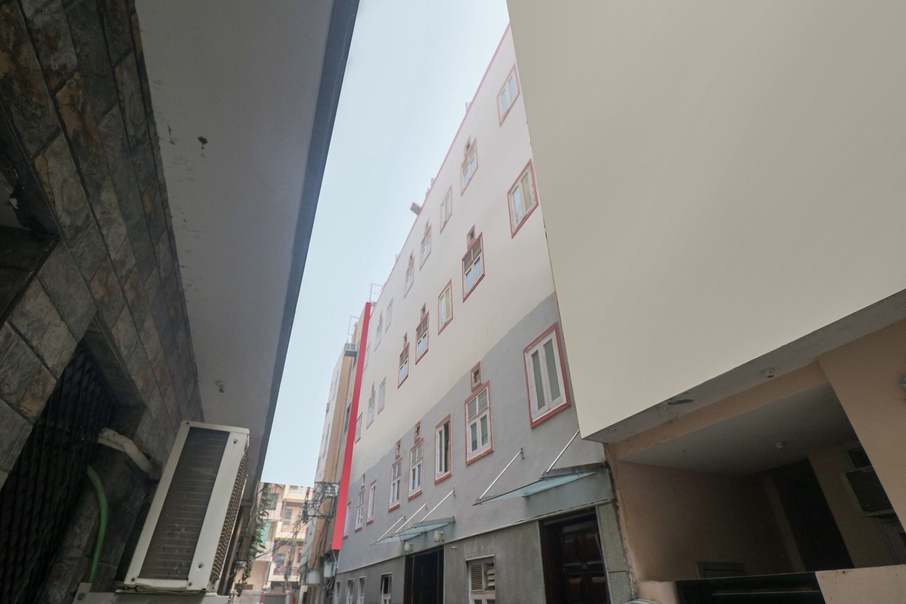 Une rue étroite bordée de bâtiments des deux côtés, où se côtoient des immeubles d’habitation et des locaux commerciaux.