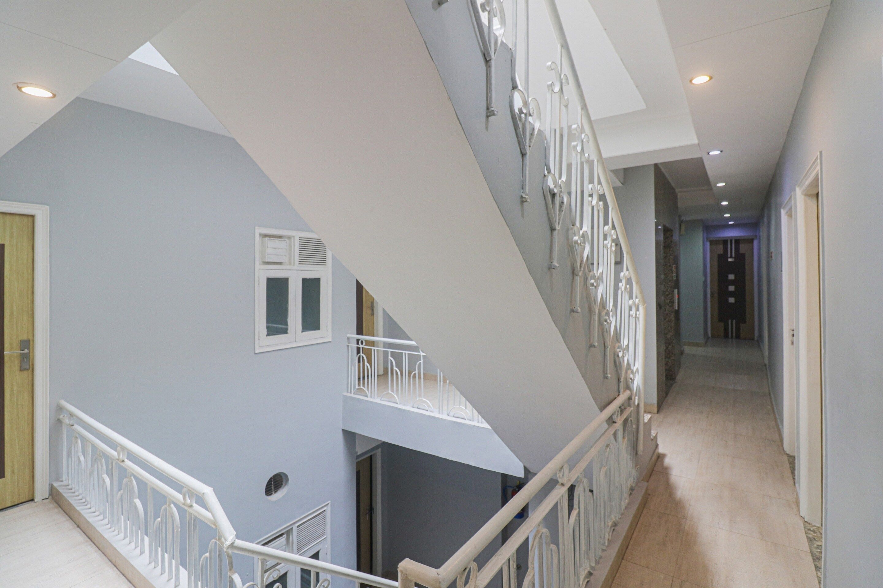 A multi-level interior with a staircase, railings, and a hallway.