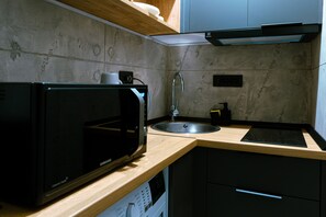 A kitchen with a microwave, sink, and a built-in oven.