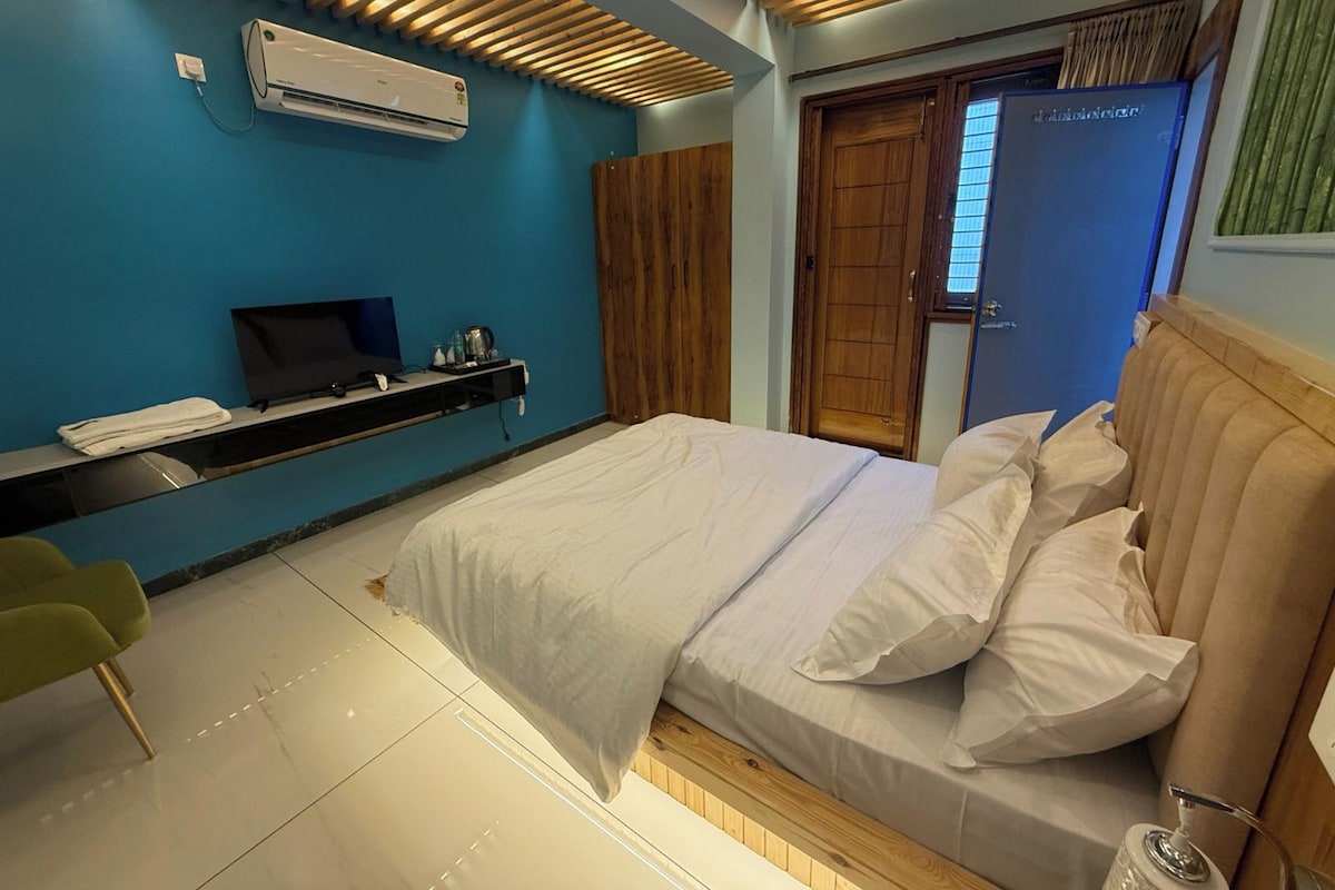 Une chambre à coucher moderne, équipée d’un lit, d’une télévision, d’un bureau et d’une armoire.