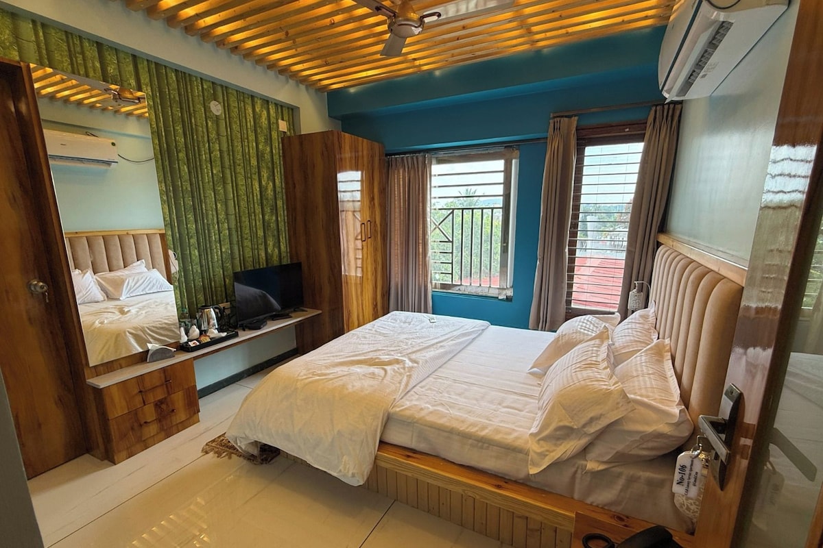 Une chambre d’hôtel avec un lit, une télévision, un bureau et une fenêtre avec des rideaux.