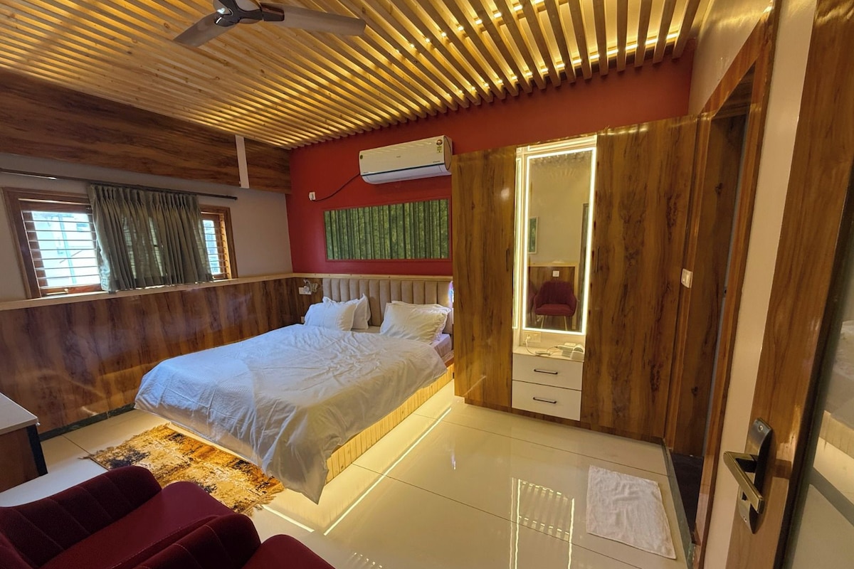 Une chambre à coucher comprenant un lit, un miroir, une armoire et un fauteuil de massage.