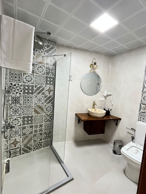 A bathroom with a shower, a sink with a mirror, and a toilet. - Marsel Rooms (İzmir)